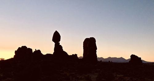 Silhouette of rock formations against sky during sunset