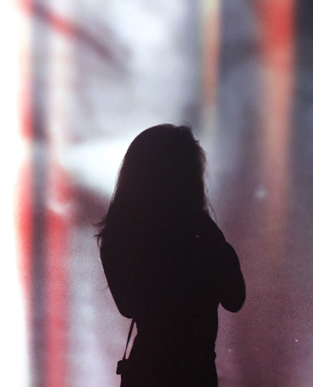 SILHOUETTE OF WOMAN AGAINST BLURRED BACKGROUND