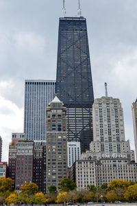 Low angle view of buildings against cloudy sky