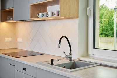 Interior of a modern kitchen with sink near window