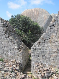 Low angle view of stone wall against sky