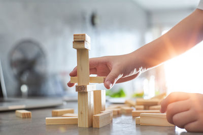 Cropped hands of boy holding wooden block