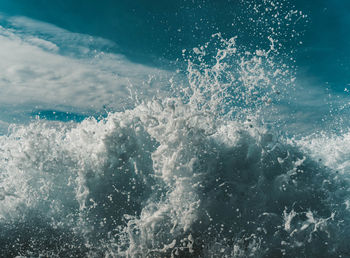 Water splashing in sea against sky