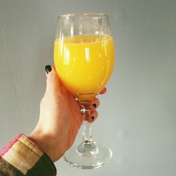 Close-up of hand holding drink over white background