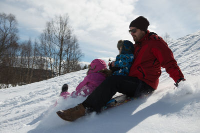 Father children in winter wonderland on sunny day on snow mountain