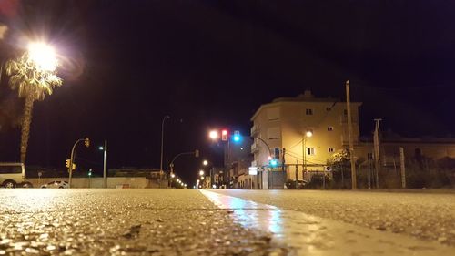 Illuminated city street against sky at night