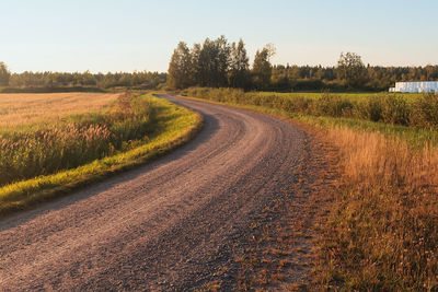 Road amidst field against sky