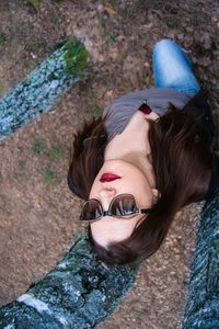 High angle view of woman wearing sunglasses while standing in forest