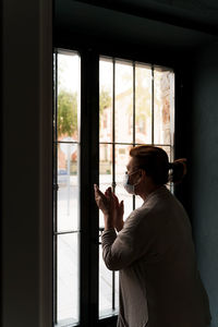 Side view of man holding glass window