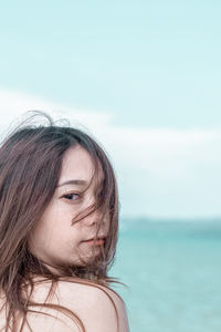 Close-up of young woman against sea