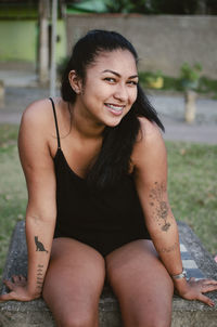 Portrait of a smiling young woman sitting outdoors