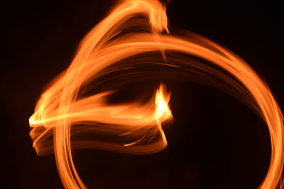 Close-up of lit candle against black background