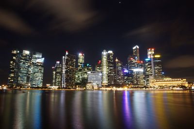 Illuminated cityscape against sky at night