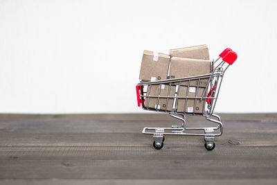 Close-up of shopping cart with boxes on table