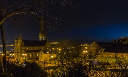 Illuminated buildings against sky at night