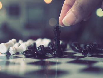 Cropped hand of woman playing chess