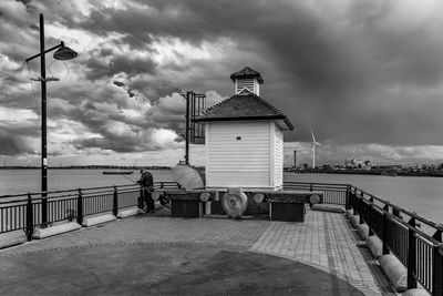 Man on pier by sea against sky