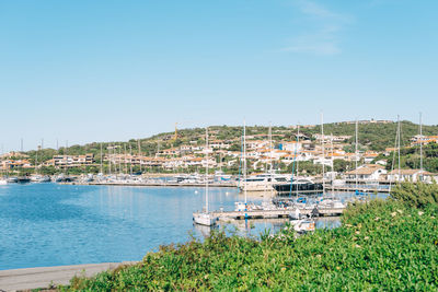 Scenic view of townscape by river against clear sky