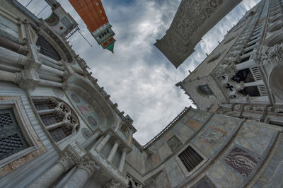 Low angle view of buildings against cloudy sky