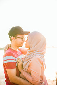 Side view of man and woman against clear sky