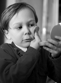 Boy applying face powder at home