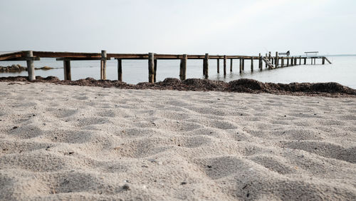 Scenic view of pier at beach against clear sky