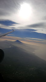 Airplane flying over landscape against sky