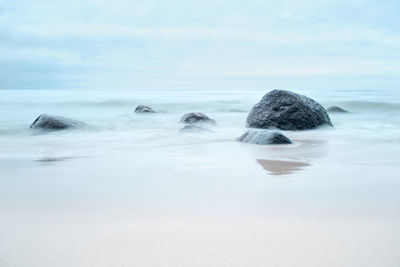 Rocks in sea against sky