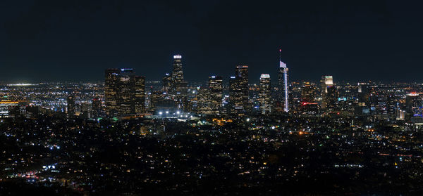 Illuminated cityscape against sky at night