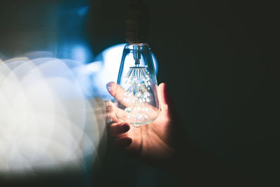 Close-up of hand holding light bulb