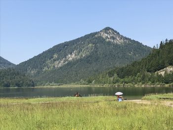 Scenic view of lake and mountains against clear sky