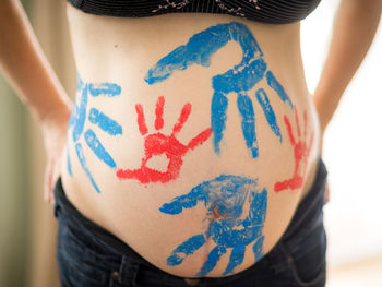 Colored handprints on moms pregnant belly