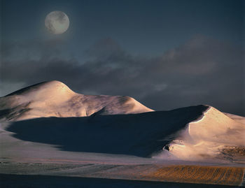 Scenic view of volcanic mountain against sky at night