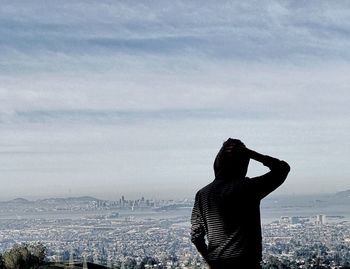 Man standing by cityscape against sky