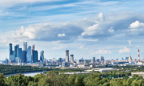 Moscow sunny panorama with green park, river and cloudy sky