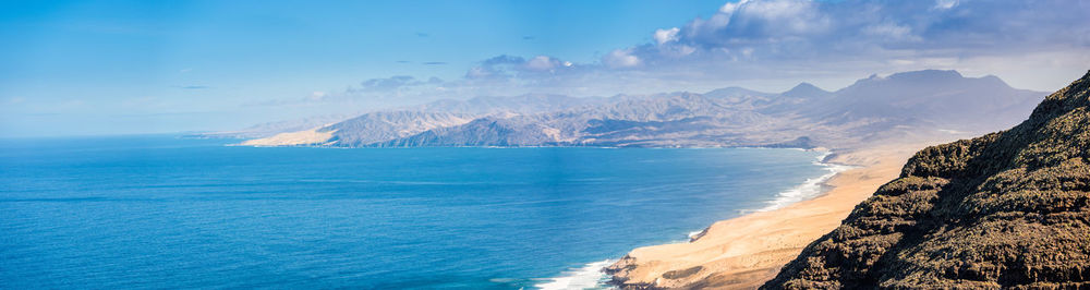 Panoramic view of sea and mountains against sky