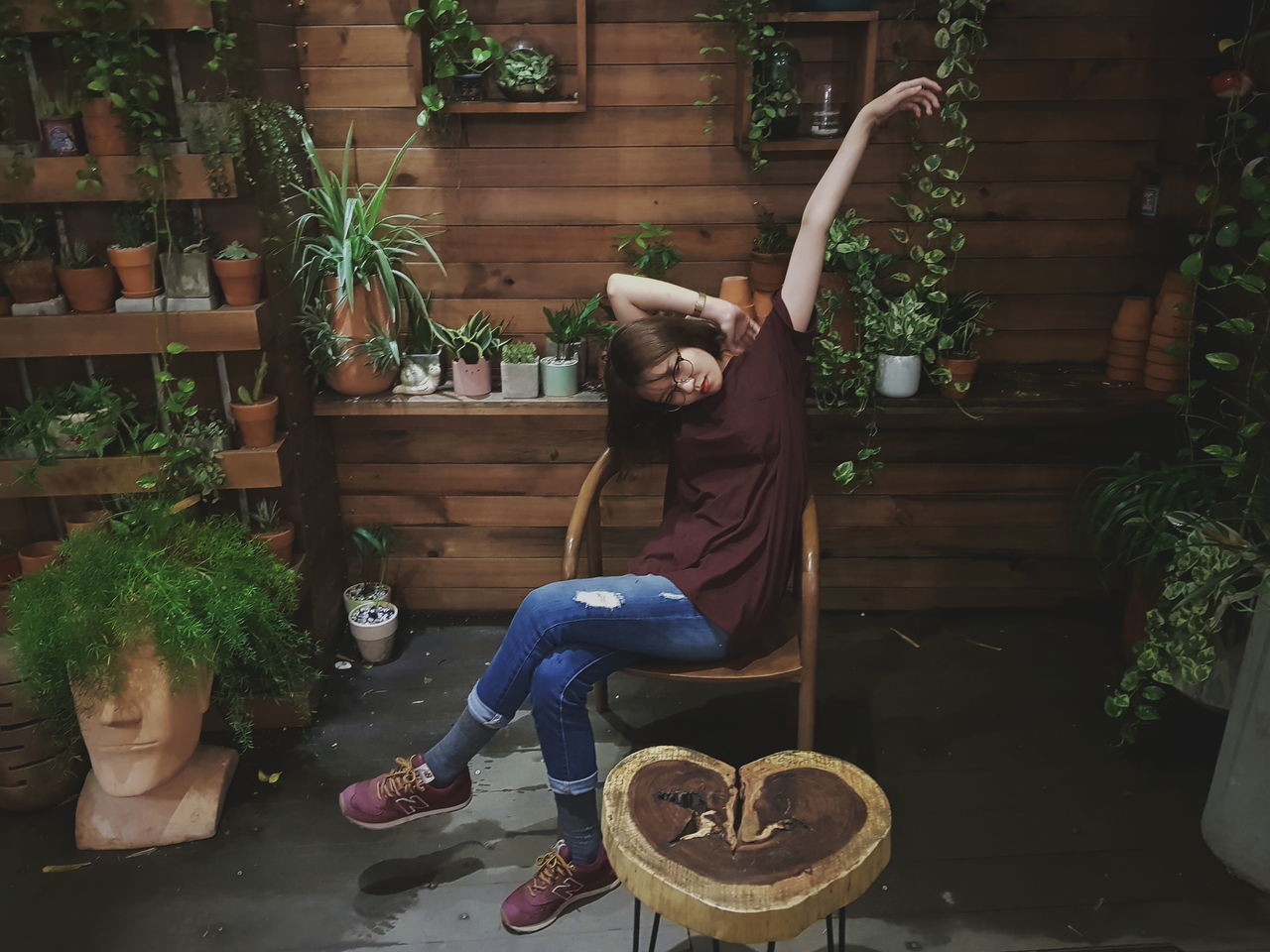 MIDSECTION OF WOMAN SITTING IN POTTED PLANT