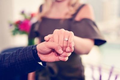 Close-up of bride and groom holding hands