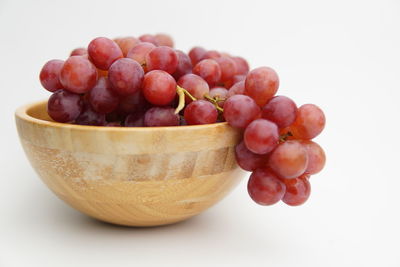 Close-up of fruits in bowl against white background