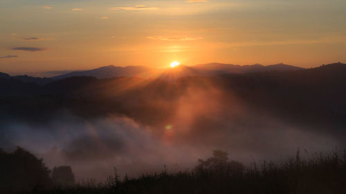 Scenic view of silhouette mountains against sky during sunset