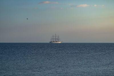 Sailboat sailing on sea against sky during sunset