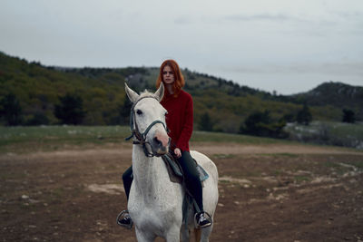 Portrait of man riding horse on field