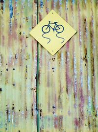 Bicycle sign on damaged corrugated iron