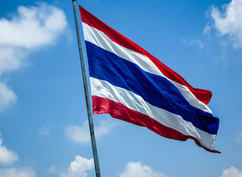 Low angle view of thai flag against blue sky