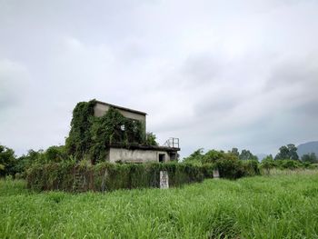 Abandoned building on field against sky