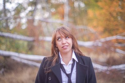 Portrait of smiling woman against trees