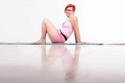 Portrait of young woman sitting on wall