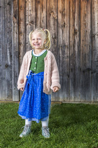 Portrait of happy girl standing on field