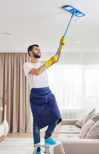 Full length of man standing against wall at home