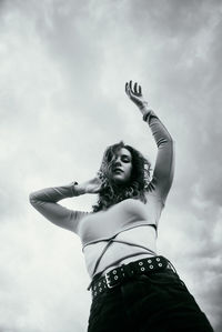Low angle view of woman standing against sky